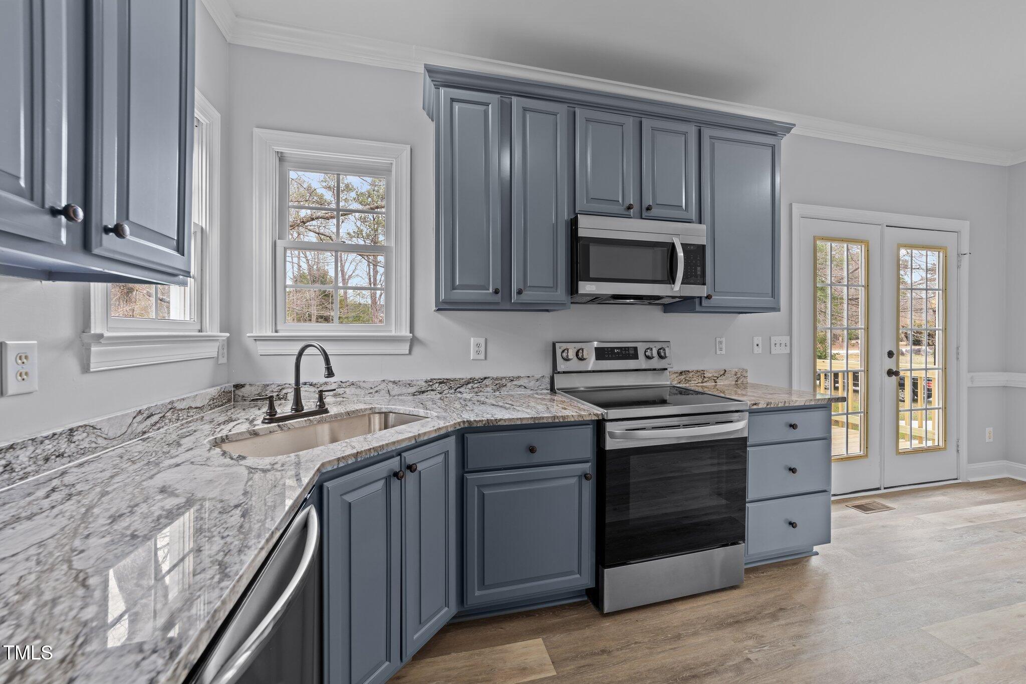 3525 La Costa Way Raleigh, NC 27610 - Photo 13 of 45 a kitchen with granite countertop a stove sink and microwave