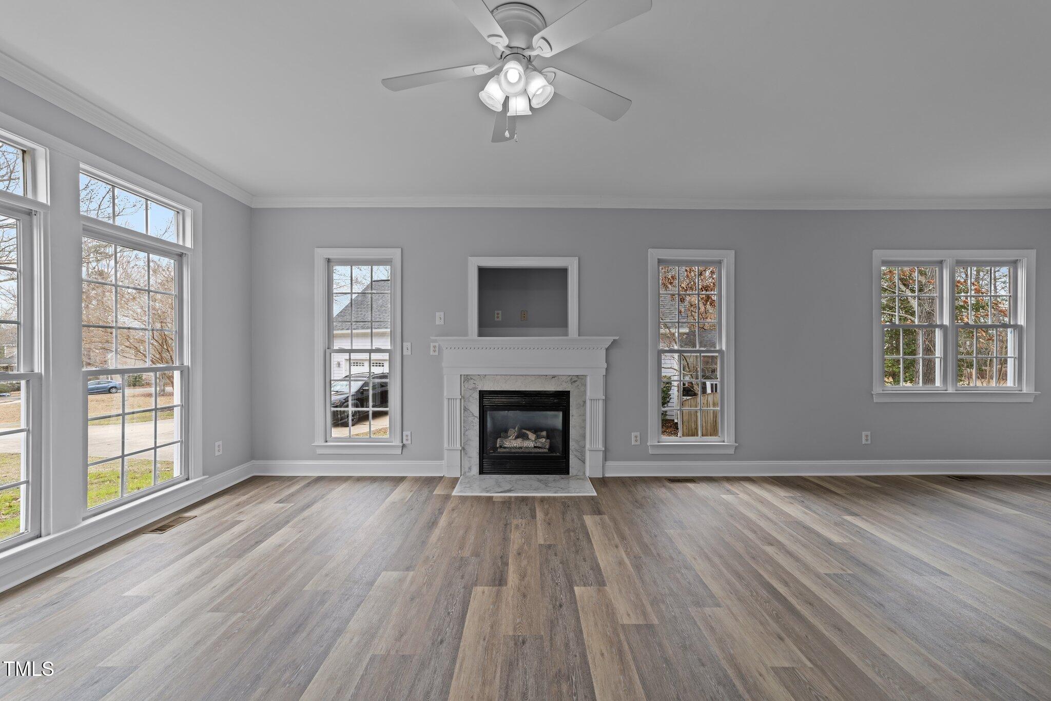 3525 La Costa Way Raleigh, NC 27610 - Photo 6 of 45 a view of an empty room with wooden floor fireplace and a window