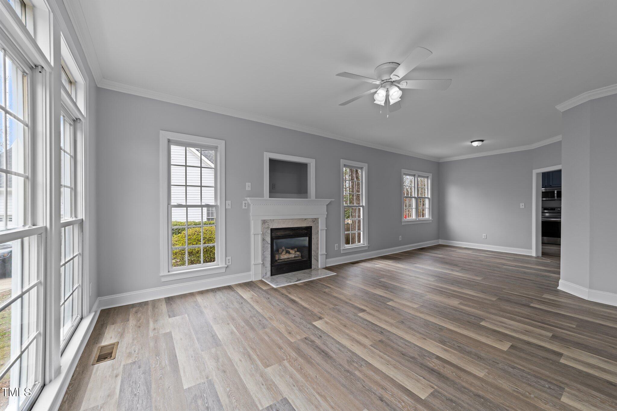 3525 La Costa Way Raleigh, NC 27610 - Photo 7 of 45 wooden floor fireplace and windows in an empty room