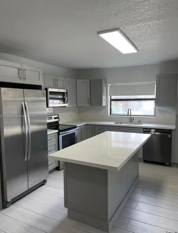 a large kitchen with a stove a sink and a refrigerator