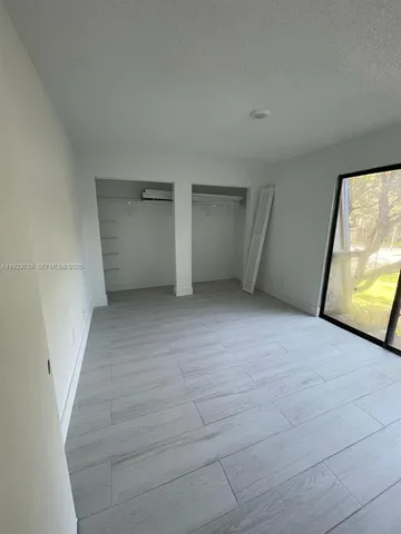 a view of an empty room with a fireplace and a window