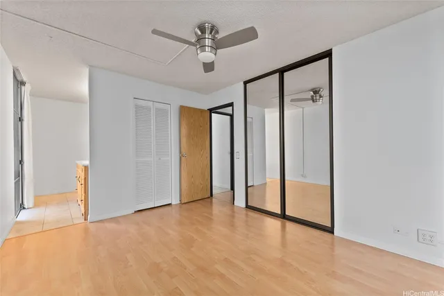 a view of a big room with wooden floor and a ceiling fan