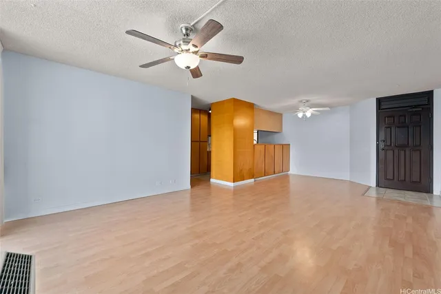 a view of an empty room with a chandelier fan and a window