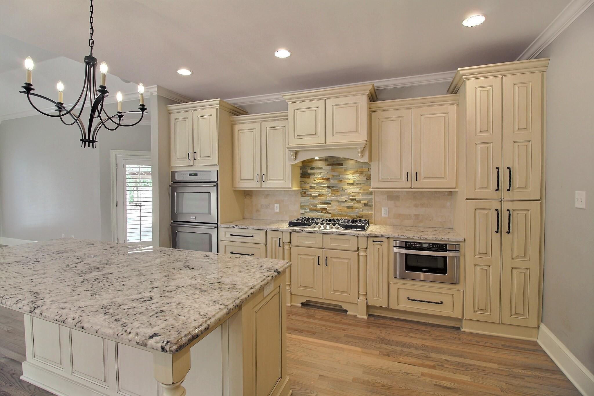 595 Kenrose Street Collierville, TN 38017 - Photo 11 of 38 a kitchen with kitchen island granite countertop a stove a sink and a refrigerator