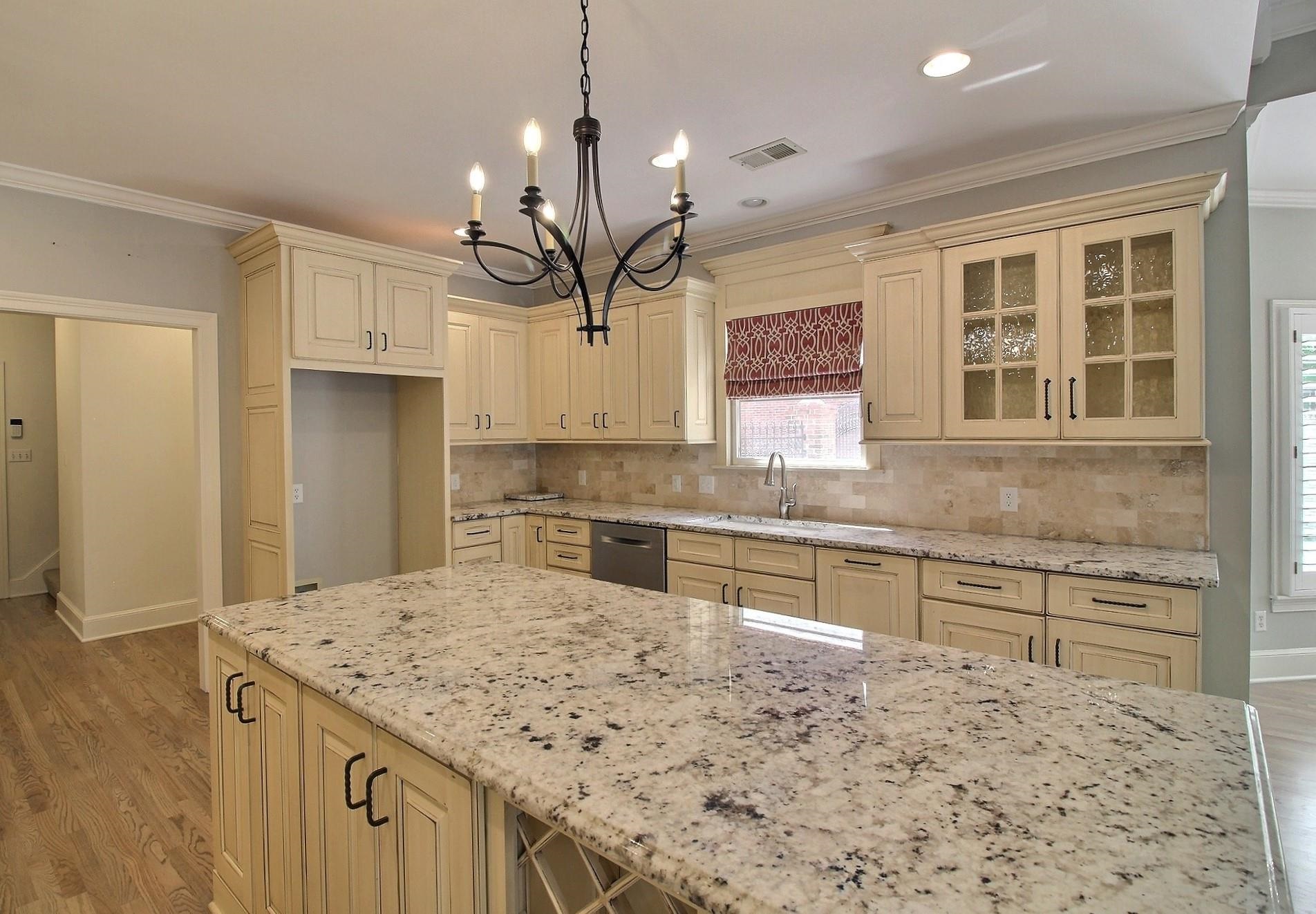 595 Kenrose Street Collierville, TN 38017 - Photo 12 of 38 a kitchen with kitchen island granite countertop a sink cabinets and window