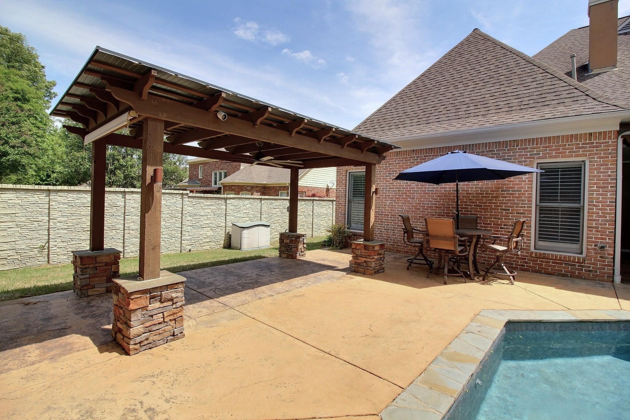595 Kenrose Street Collierville, TN 38017 - Photo 33 of 38 a view of a patio with table and chairs under an umbrella with a barbeque