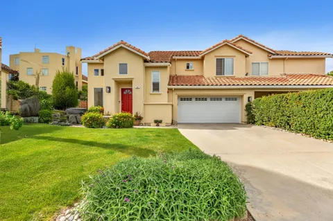 a front view of a house with a garden and yard