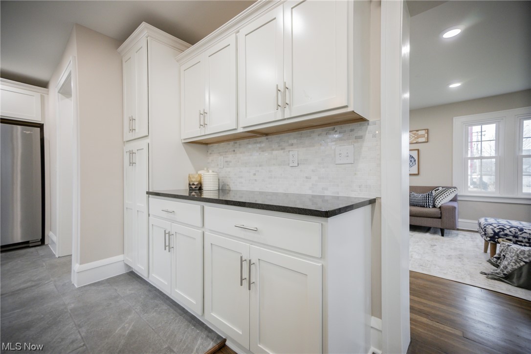 3553 Avalon Road Cleveland, OH 44120 - Photo 10 of 39 Kitchen with tasteful backsplash, stainless steel fridge, white cabinetry, and dark stone countertops