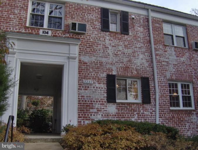 3237 Gunston Road, Unit 104 Alexandria, VA 22302 - Photo 1 of 16 a brick building with a bench in front of it