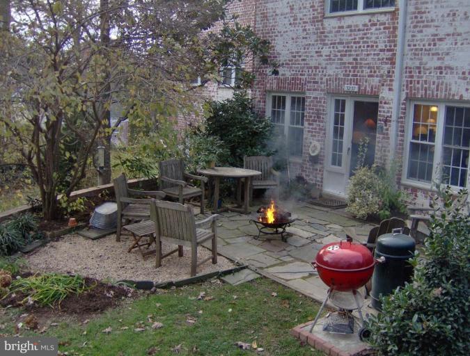 3237 Gunston Road, Unit 104 Alexandria, VA 22302 - Photo 2 of 16 a view of a backyard with table and chairs potted plants and a fire pit