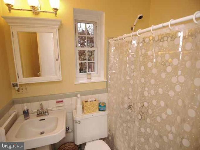 3237 Gunston Road, Unit 104 Alexandria, VA 22302 - Photo 10 of 16 a bathroom with a sink a toilet and shower curtain