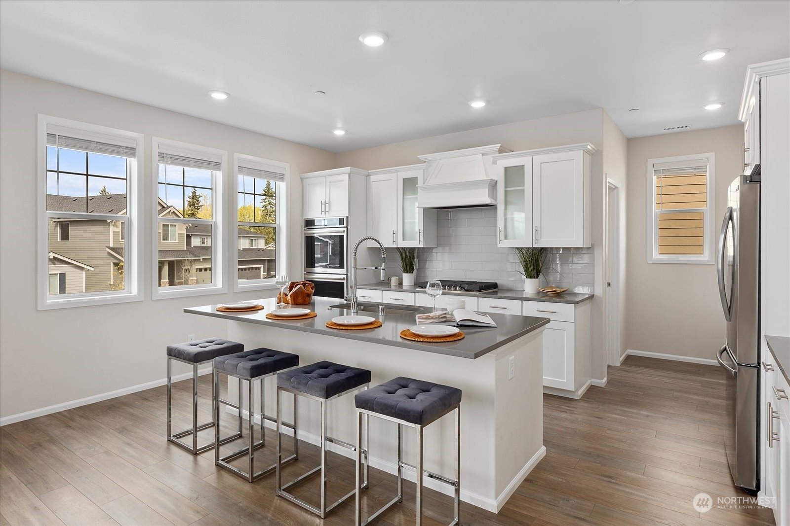 23317 41st Drive Southeast Bothell, WA 98021 - Photo 10 of 40 a kitchen with a stove a sink a kitchen island with a dining table and wooden floor