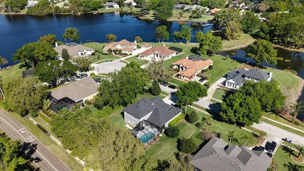 an aerial view of a house with a yard and lake view