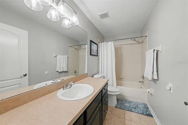 a bathroom with a sink a toilet a mirror and shower