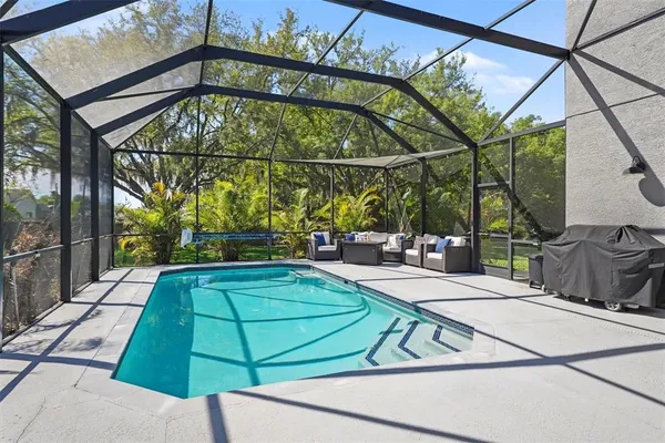a view of a swimming pool with a patio and a yard