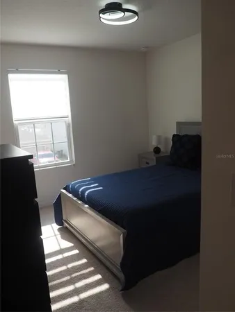a bed sitting in a bedroom next to a window