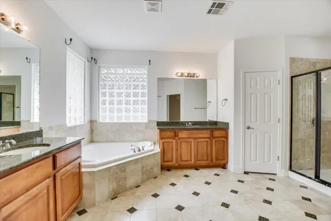 a large bathroom with a granite countertop tub sink and a mirror