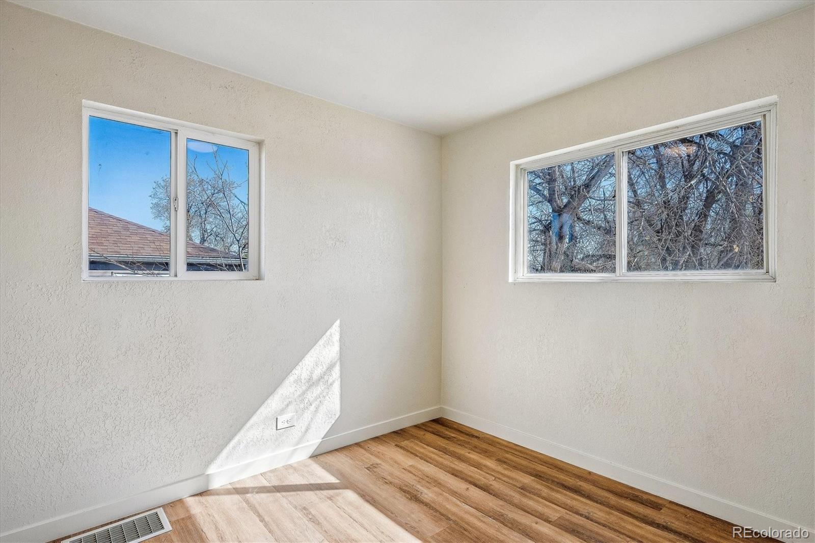 802 Julian Street Denver, CO 80204 - Photo 12 of 17 a view of an empty room with wooden floor and a window