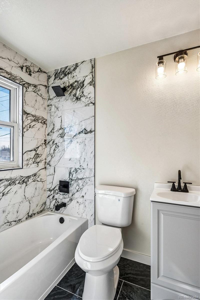 802 Julian Street Denver, CO 80204 - Photo 15 of 17 a bathroom with a bathtub sink mirror and toilet