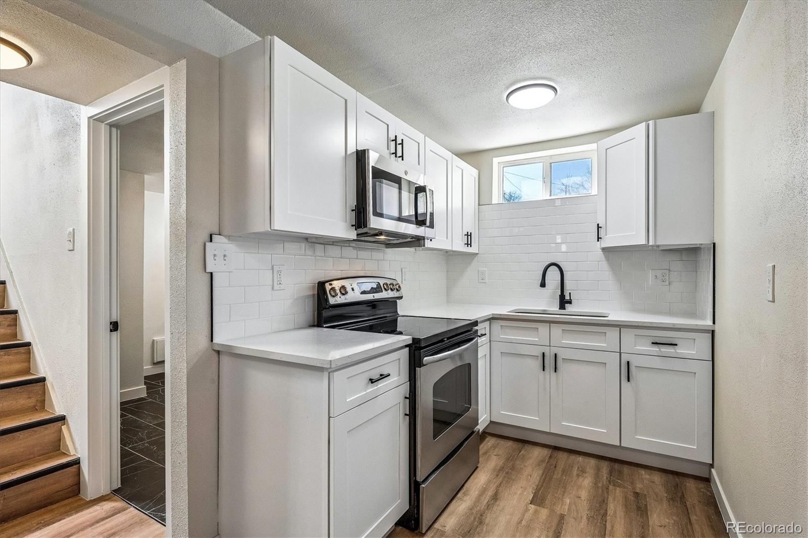 802 Julian Street Denver, CO 80204 - Photo 16 of 17 a kitchen with stainless steel appliances granite countertop a sink stove and refrigerator