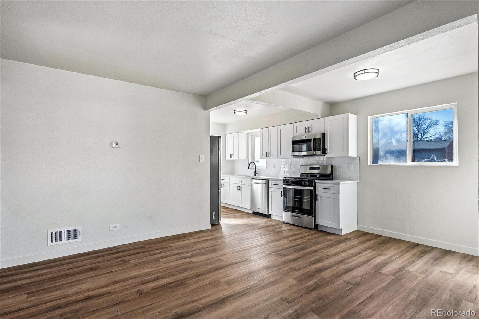 802 Julian Street Denver, CO 80204 - Photo 2 of 17 a kitchen with stainless steel appliances a refrigerator sink and stove