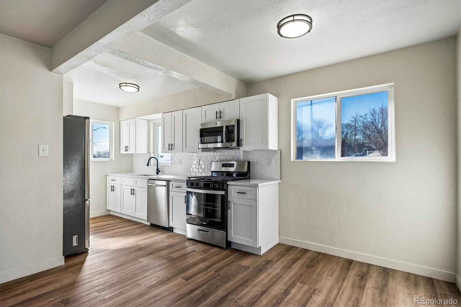 802 Julian Street Denver, CO 80204 - Photo 4 of 17 a kitchen with a refrigerator stove and wooden floor