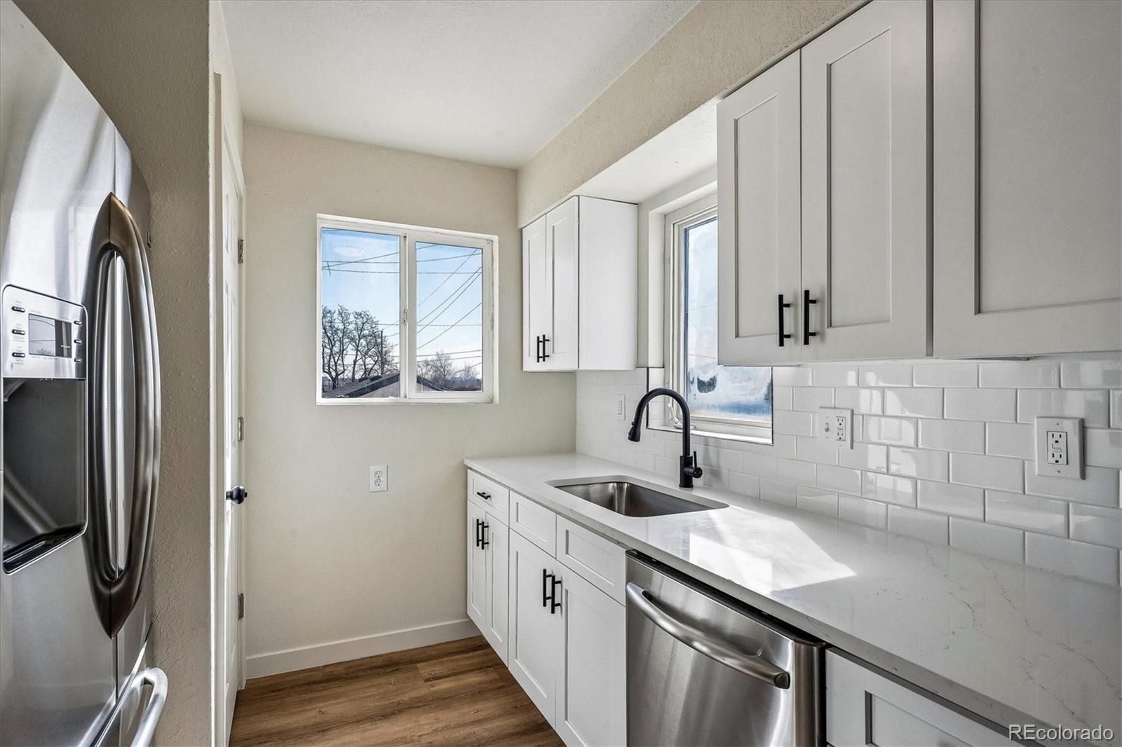 802 Julian Street Denver, CO 80204 - Photo 7 of 17 a kitchen with stainless steel appliances granite countertop a sink a refrigerator and a granite counter tops
