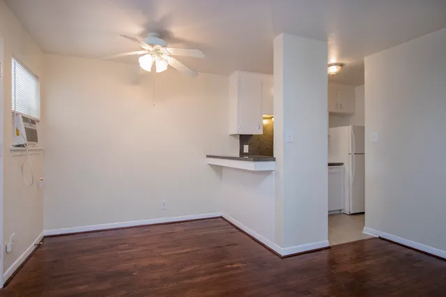 a view of a kitchen with wooden floor and a light fixture