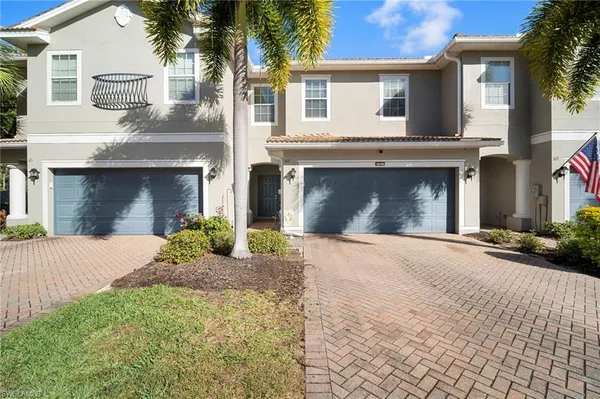 a front view of a house with yard and parking