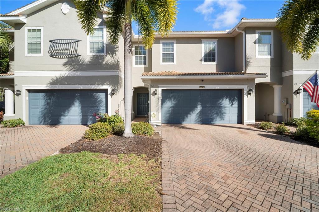 a front view of a house with yard and parking