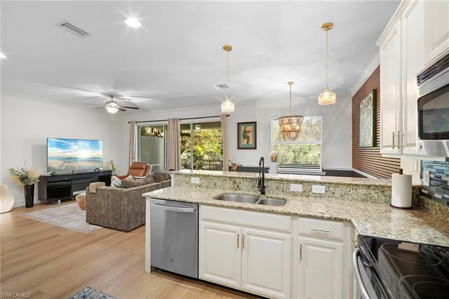 a kitchen with kitchen island granite countertop a sink cabinets and window