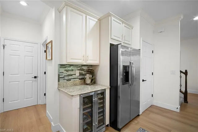 a kitchen with white cabinets and refrigerator