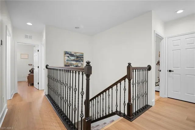 a view of a hallway with wooden floor and windows