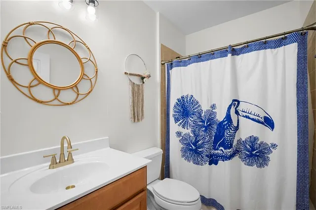 a bathroom with a toilet sink vanity tub and mirror