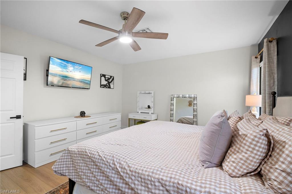 19501 Bowring Park Road, Unit 102 Fort Myers, FL 33967 - Photo 23 of 33 a bedroom with a bed and a painting on the wall