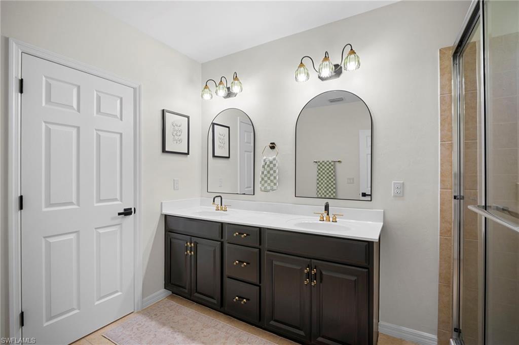 19501 Bowring Park Road, Unit 102 Fort Myers, FL 33967 - Photo 25 of 33 a spacious bathroom with a double vanity sink and a mirror