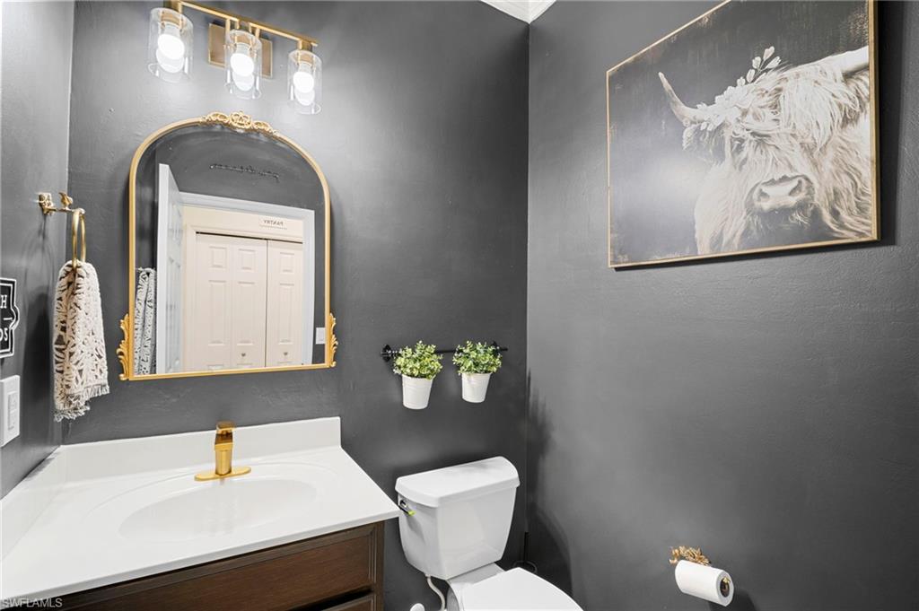 19501 Bowring Park Road, Unit 102 Fort Myers, FL 33967 - Photo 28 of 33 a bathroom with a toilet sink and mirror