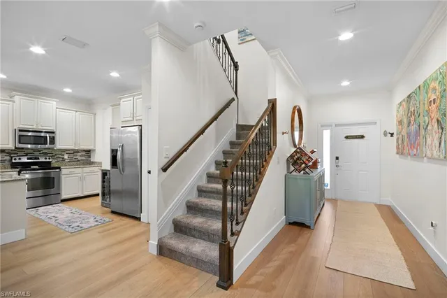 a view of a kitchen center island wooden floor and stainless steel appliances