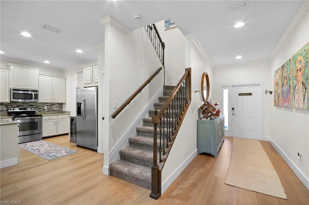 19501 Bowring Park Road, Unit 102 Fort Myers, FL 33967 - Photo 3 of 33 a view of a kitchen center island wooden floor and stainless steel appliances