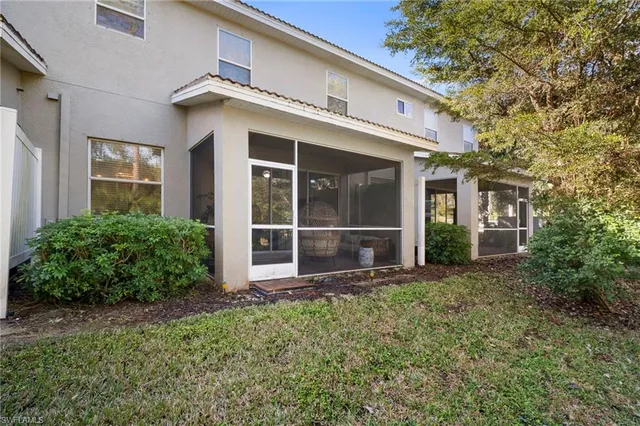 a view of a house with large windows and plants