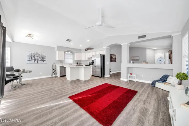 a living room with furniture pool table and kitchen view