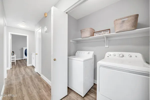 a view of washer and dryer with bathroom in the background