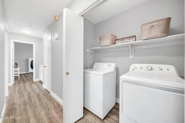 a view of washer and dryer with bathroom in the background