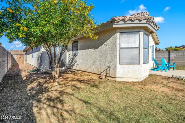 a view of a white house with a large tree