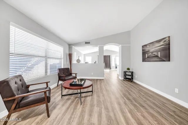 a kitchen with stainless steel appliances a refrigerator a stove a dining table and chairs with wooden floor