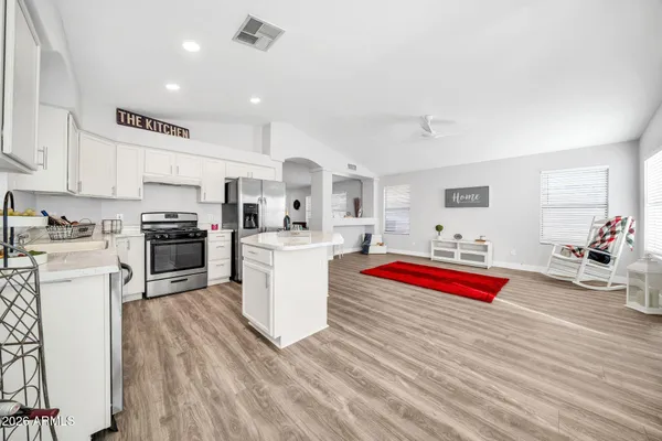 a kitchen with stainless steel appliances granite countertop a stove and white cabinets