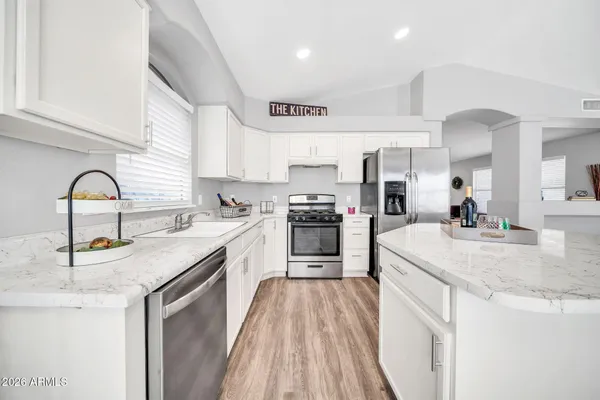 a kitchen with stainless steel appliances granite countertop a sink stove and refrigerator