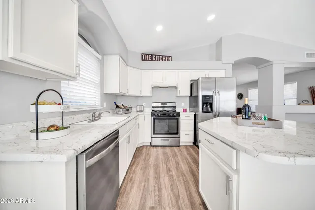 a kitchen with stainless steel appliances granite countertop a sink stove and refrigerator