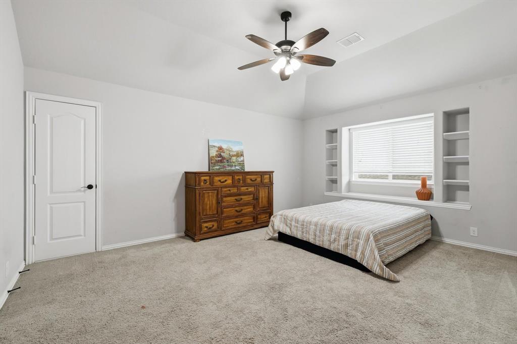 924 Timber Ridge Drive Justin, TX 76247 - Photo 30 of 32 Spacious room featuring a tray ceiling with a ceiling fan, carpet flooring, and a large window with integrated shelving