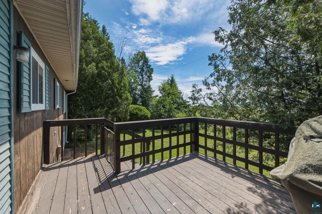 61018 Dahlstrom Road Ashland, WI 54806 - Photo 22 of 28 Expansive wooden deck with dark railings, providing an open-air extension of the home